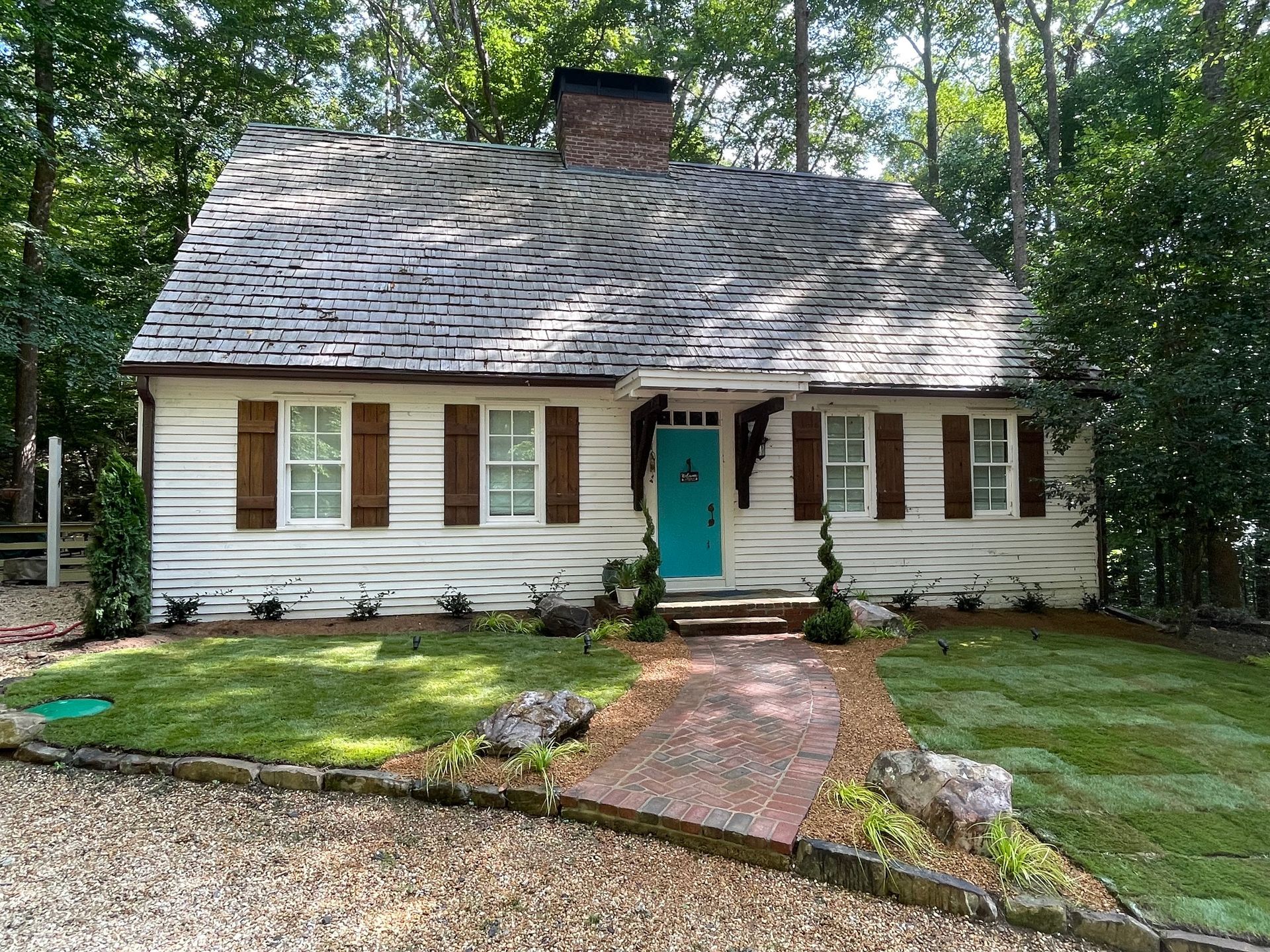 A white house with a blue door and brown shutters