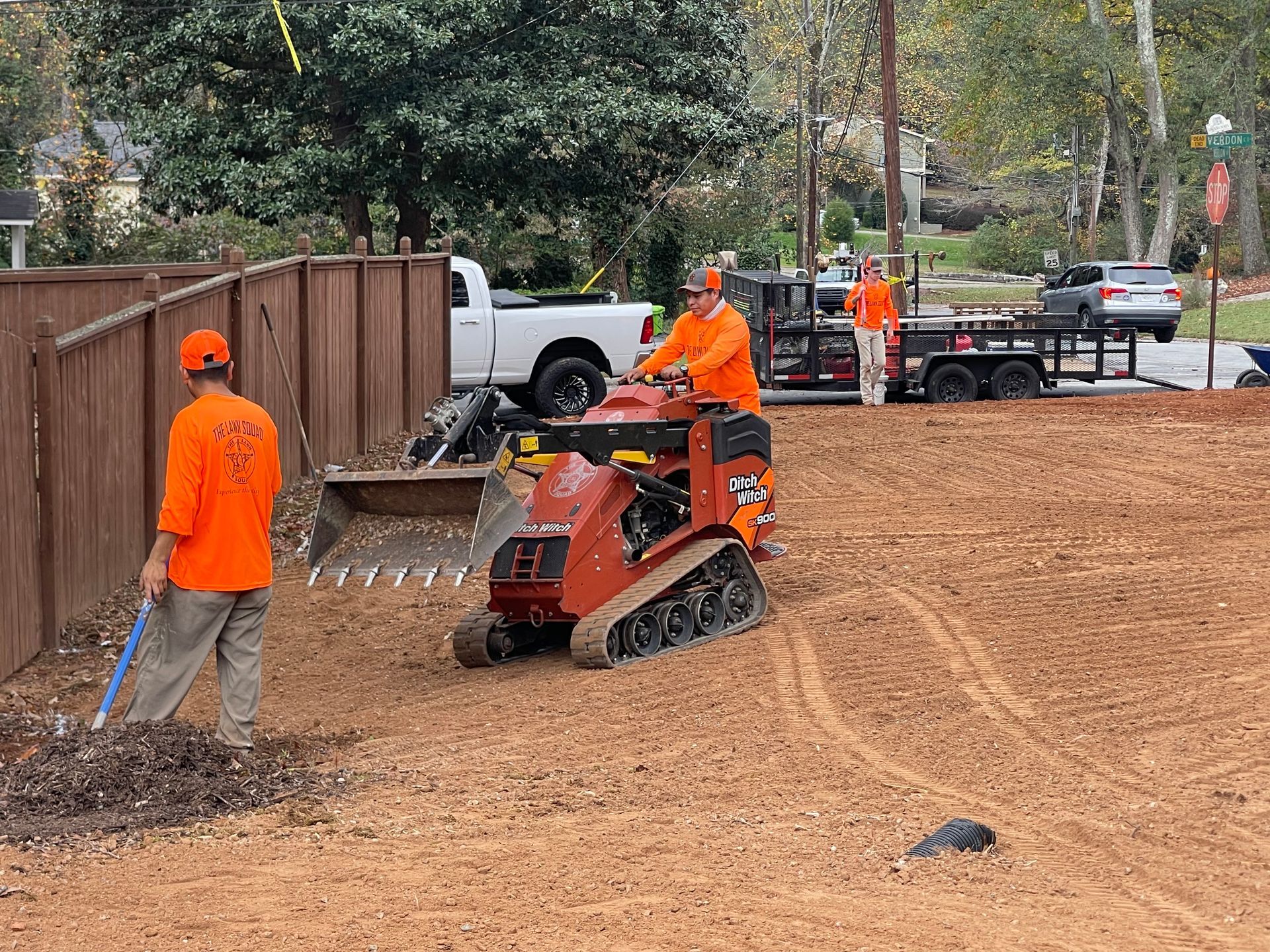 A group of men are working on a dirt field.