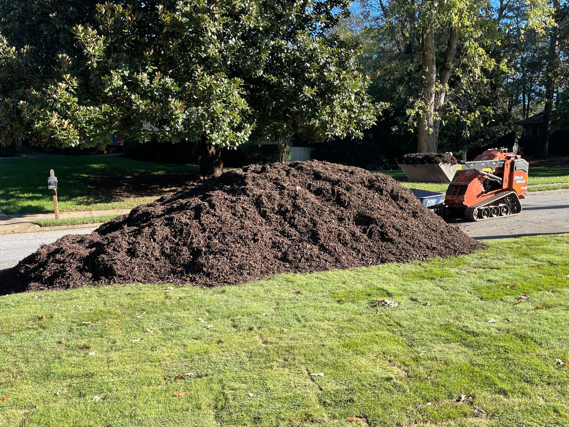 A pile of mulch is sitting on top of a lush green lawn.