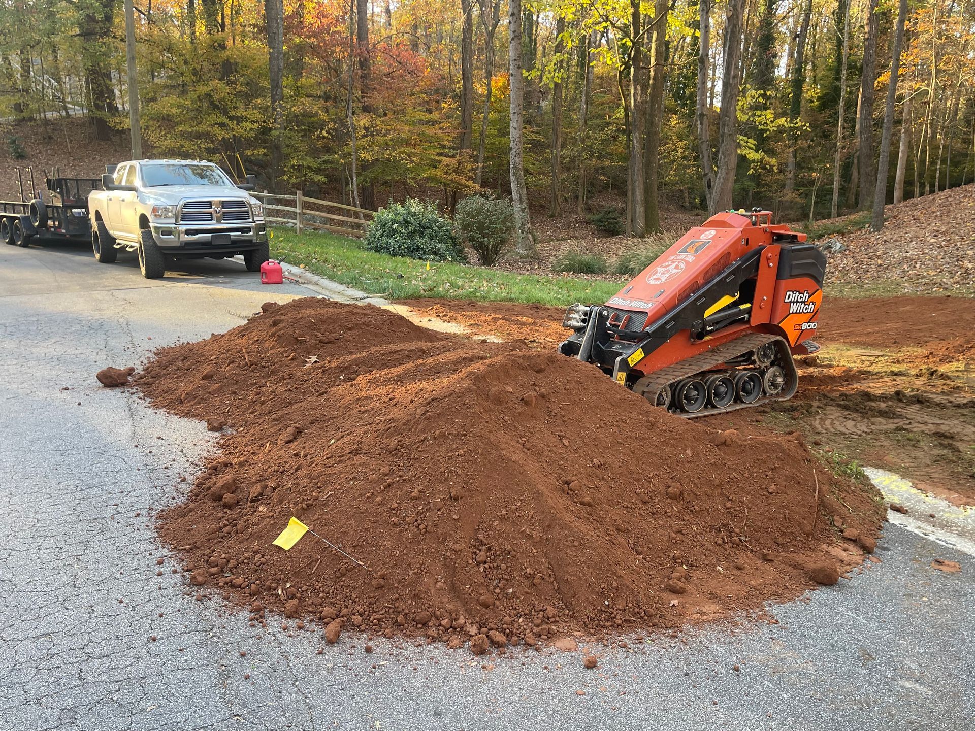 A truck is driving down a road next to a pile of dirt.