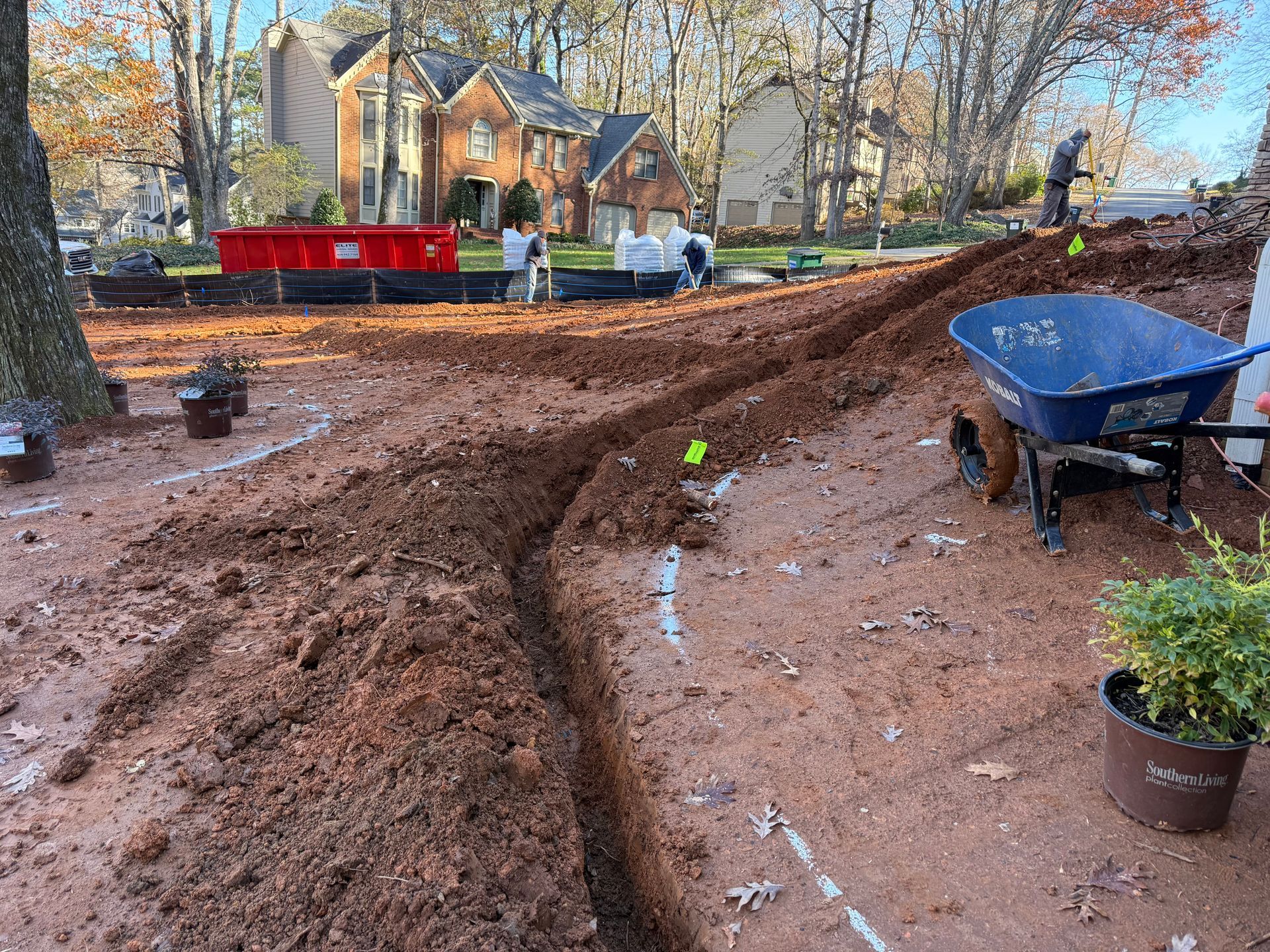 A wheelbarrow is sitting in the middle of a dirt field.