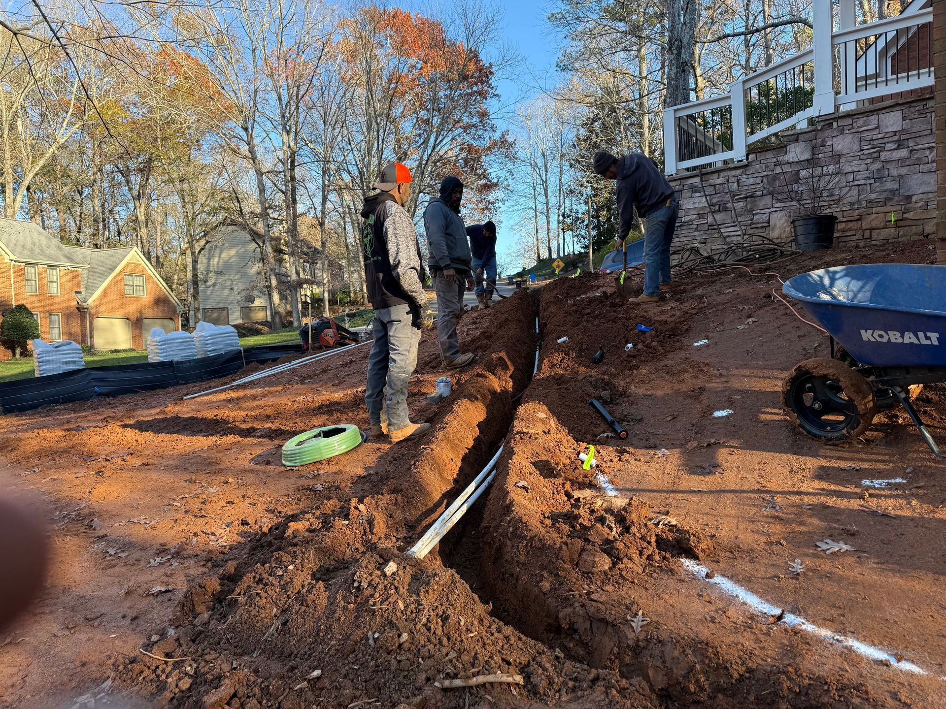 A group of men are digging a trench in the dirt.