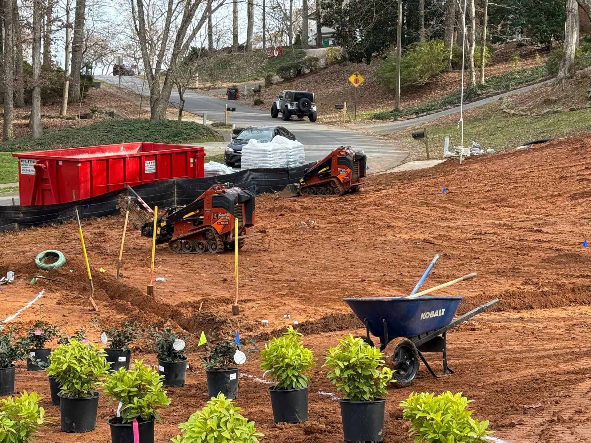 A wheelbarrow is sitting in the middle of a dirt field.