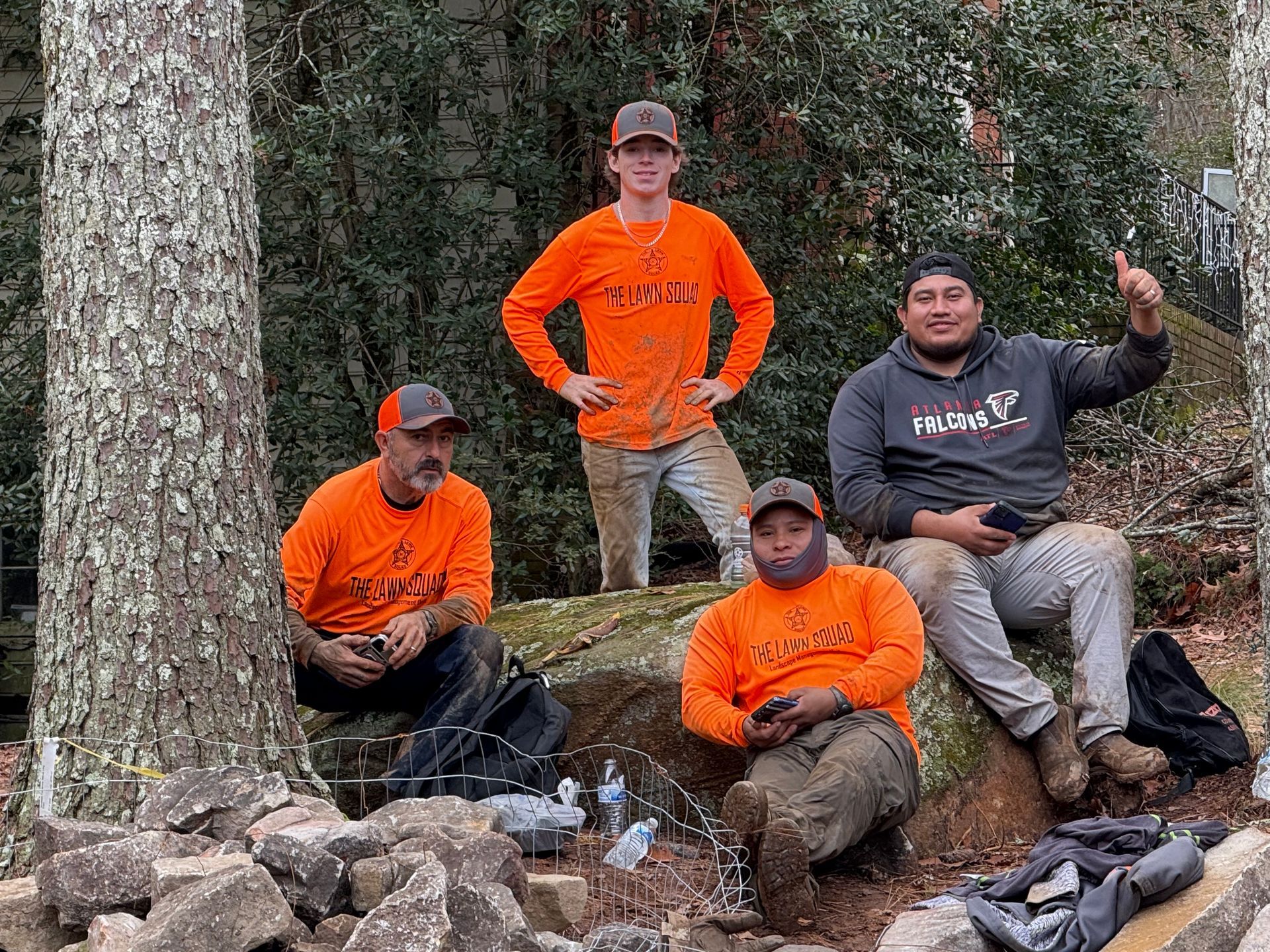 A group of men are sitting on rocks in the woods.