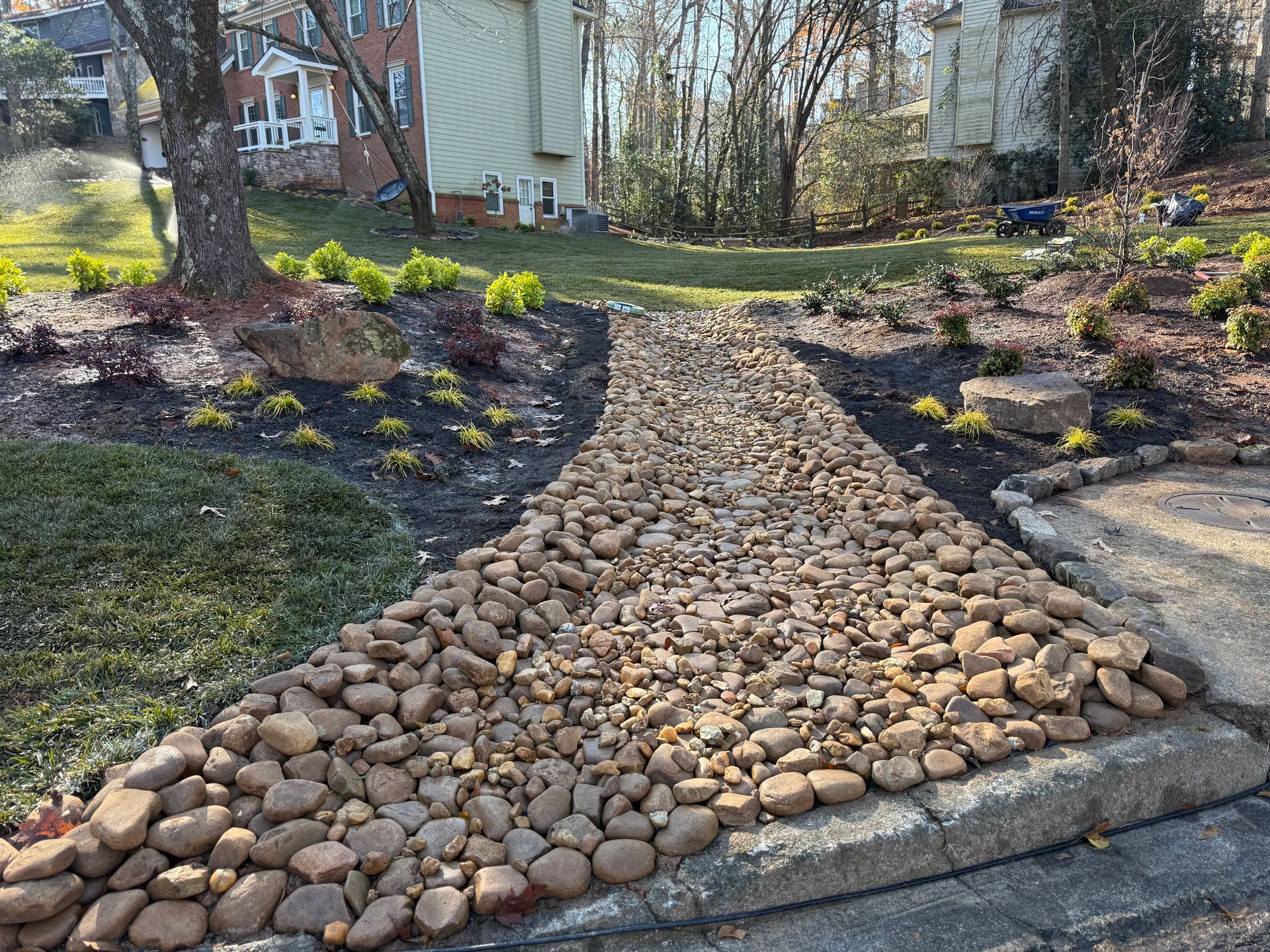A stone walkway leading to a house in a yard.