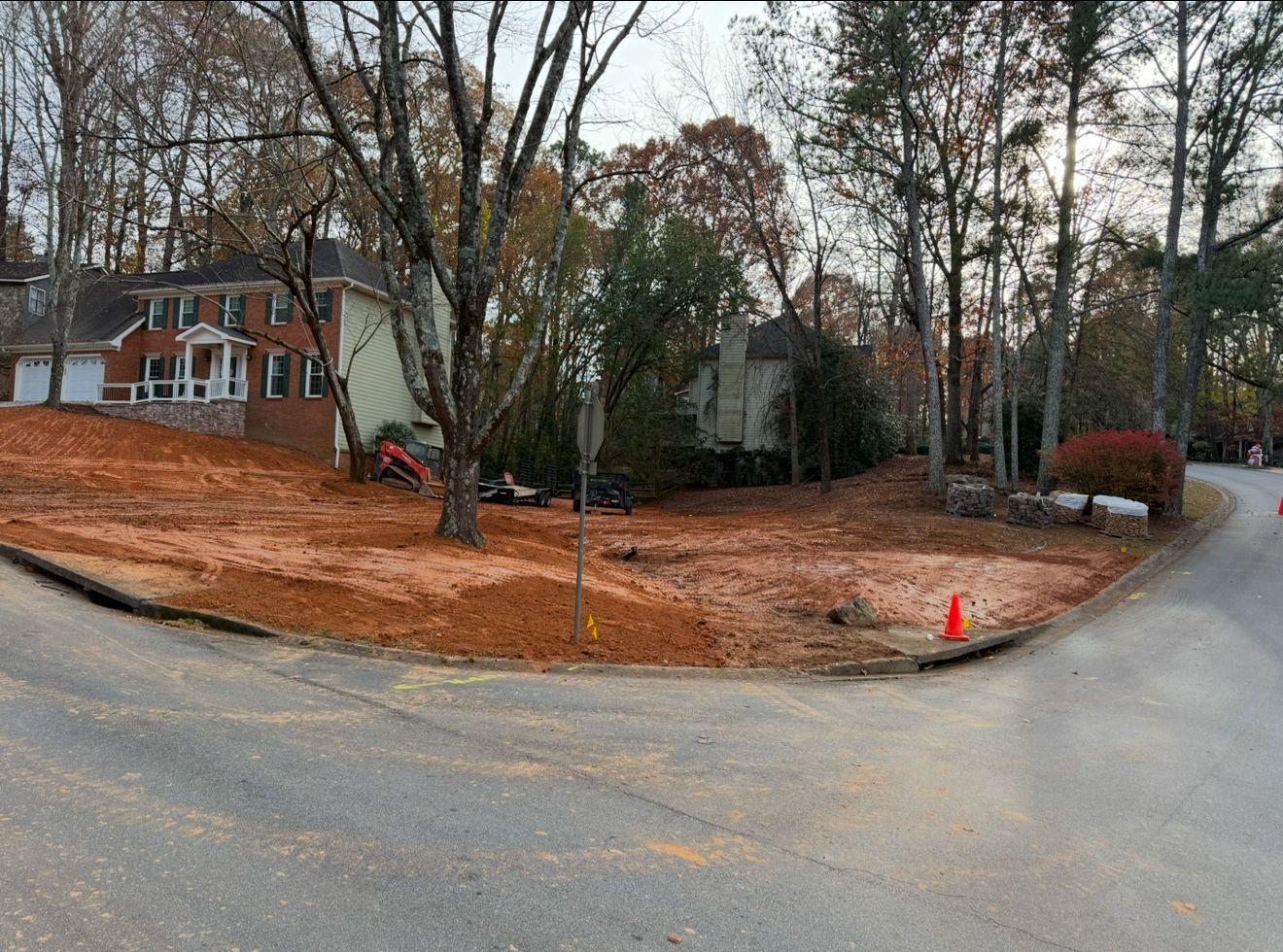 A house is being built on a dirt lot next to a road.