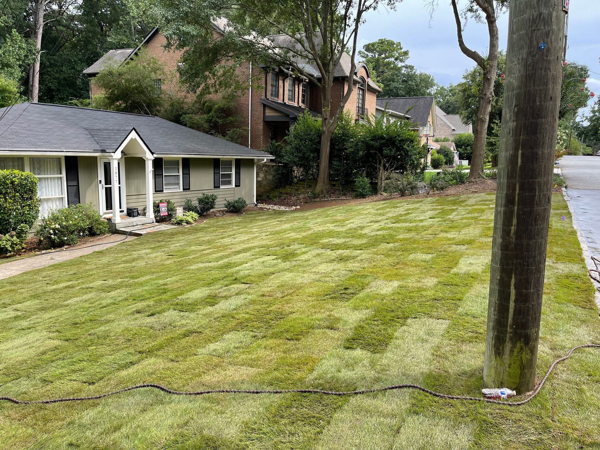 A house with a lush green lawn in front of it.