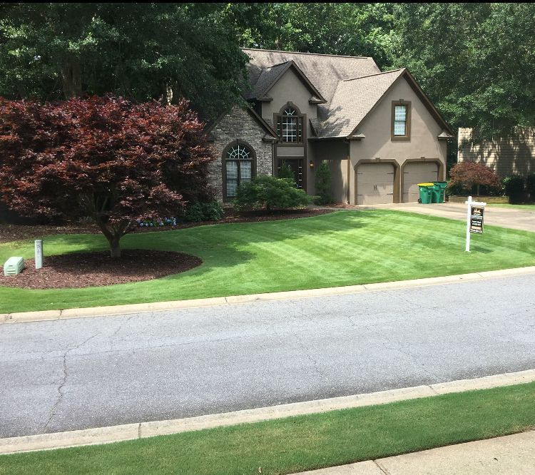 A house with a lush green lawn is for sale