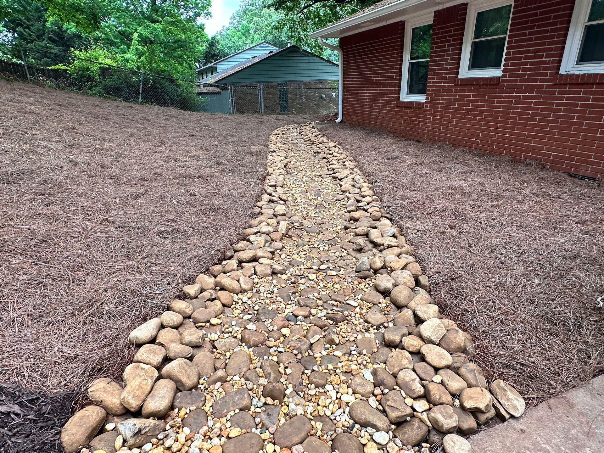 A path made of rocks leading to a brick house.