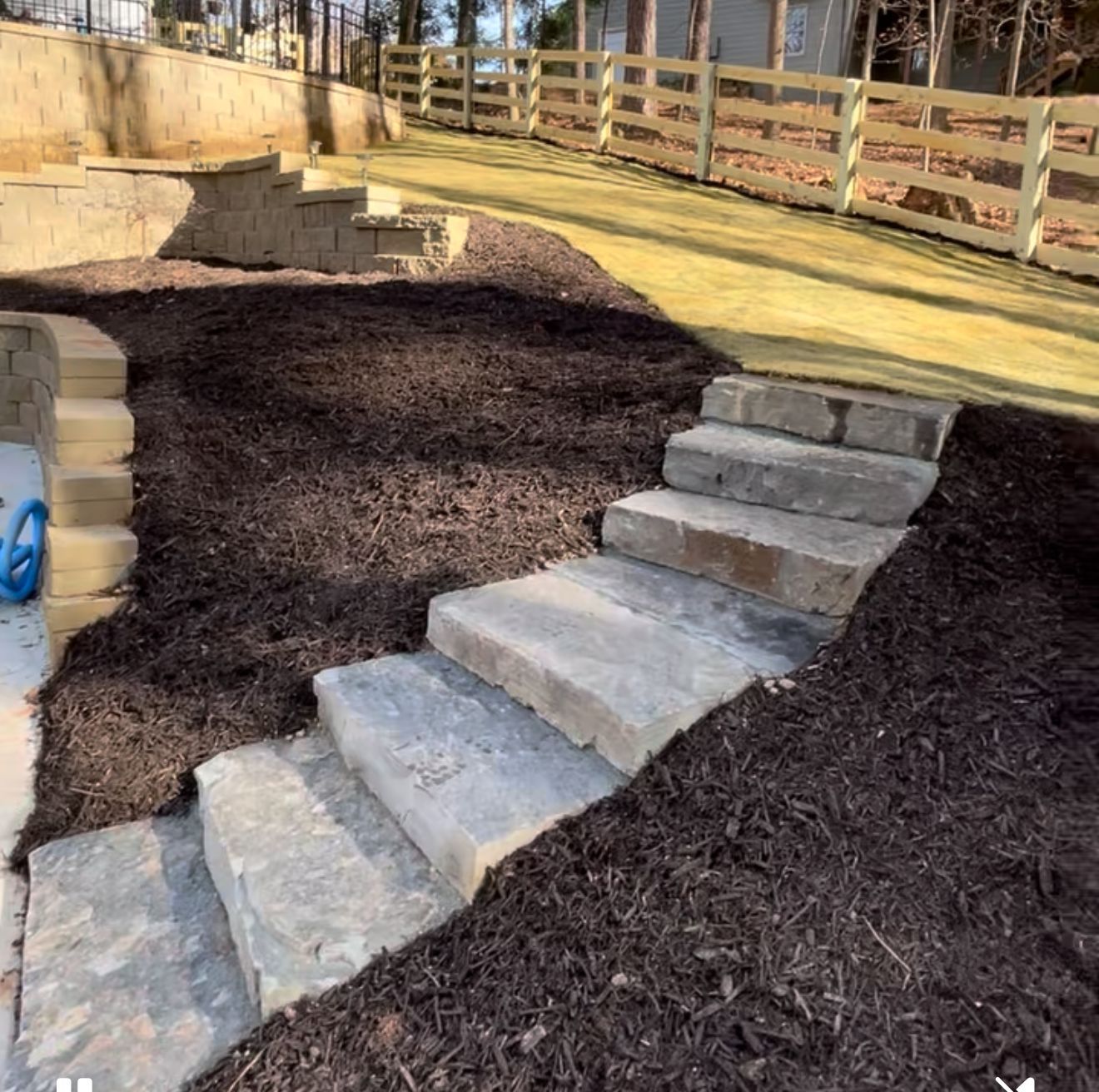 A row of stone steps leading up to a grassy area.