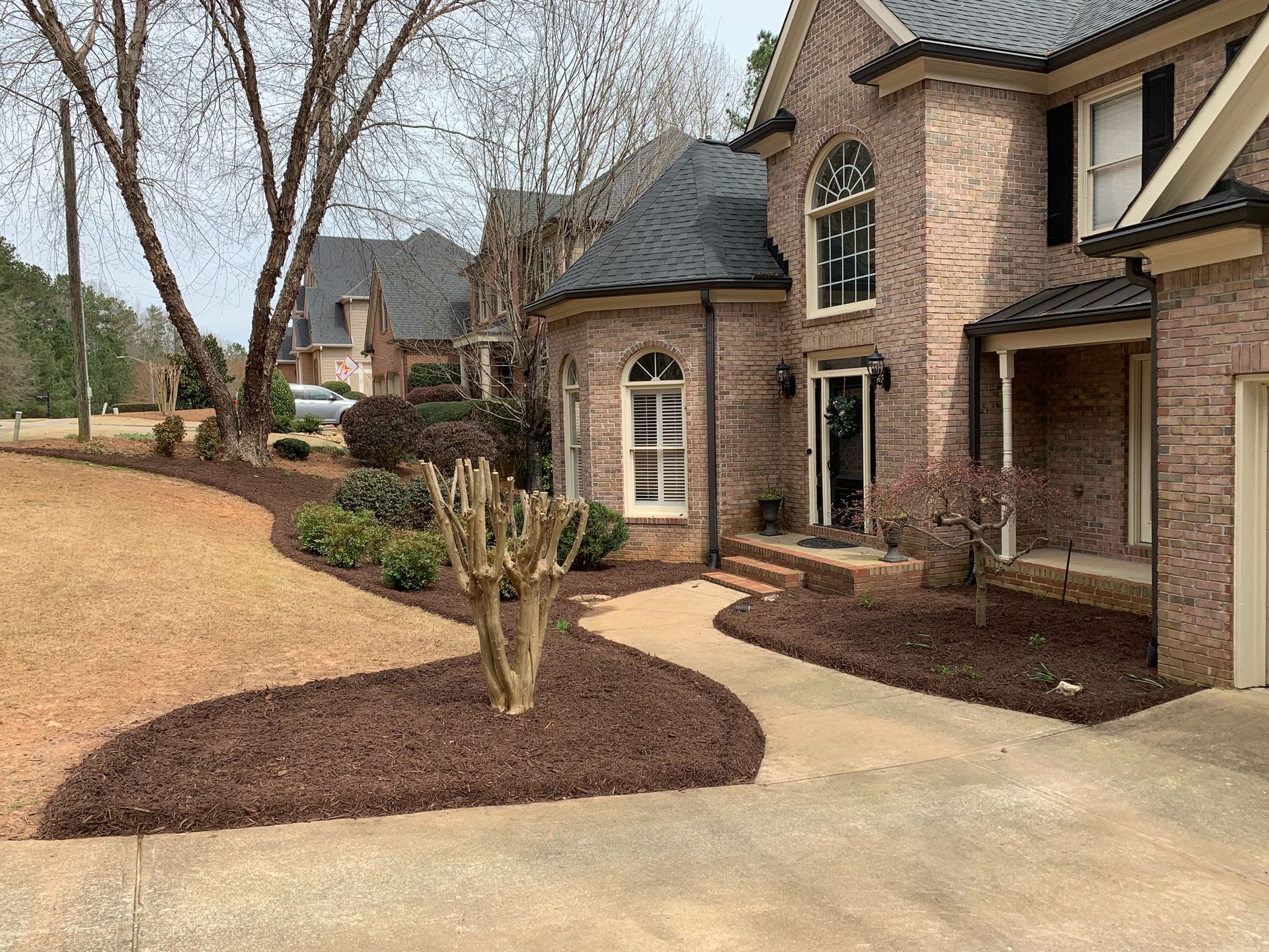 A large brick house with a walkway leading to the front door.
