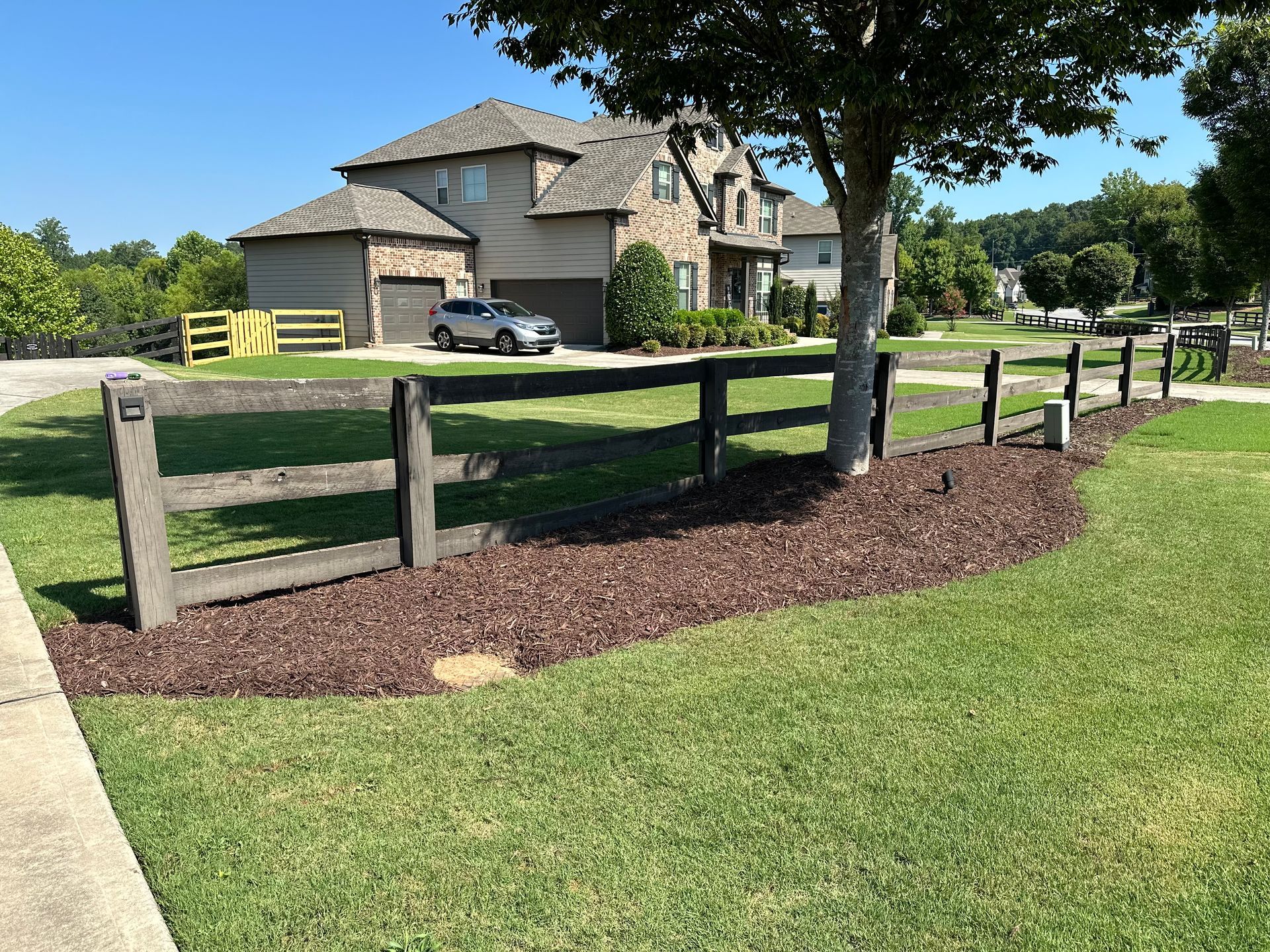 A large house with a wooden fence in front of it