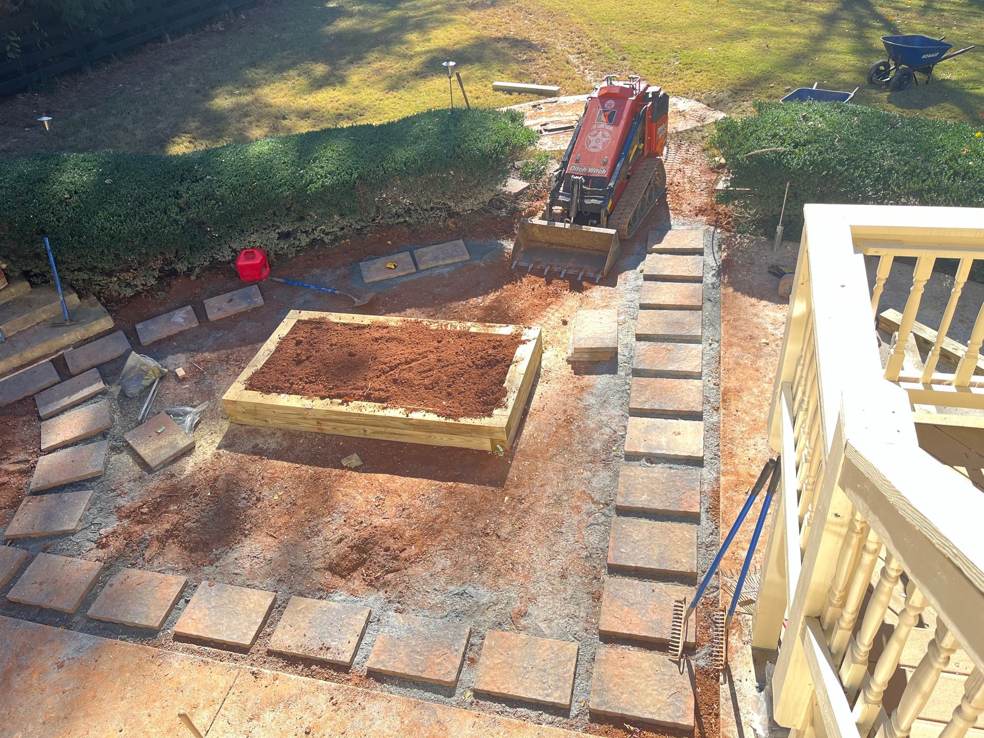 An aerial view of a garden being built with a tractor in the background