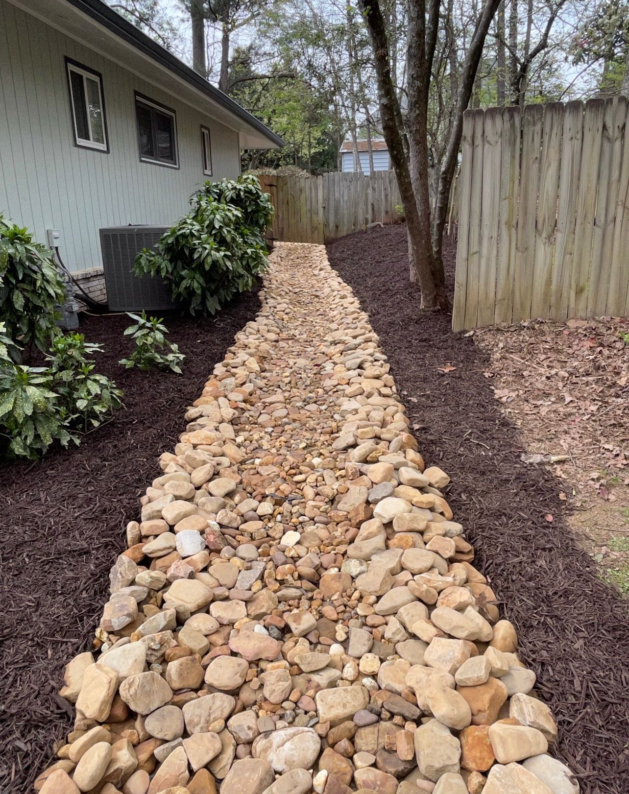 A walkway made of rocks is leading to a house.