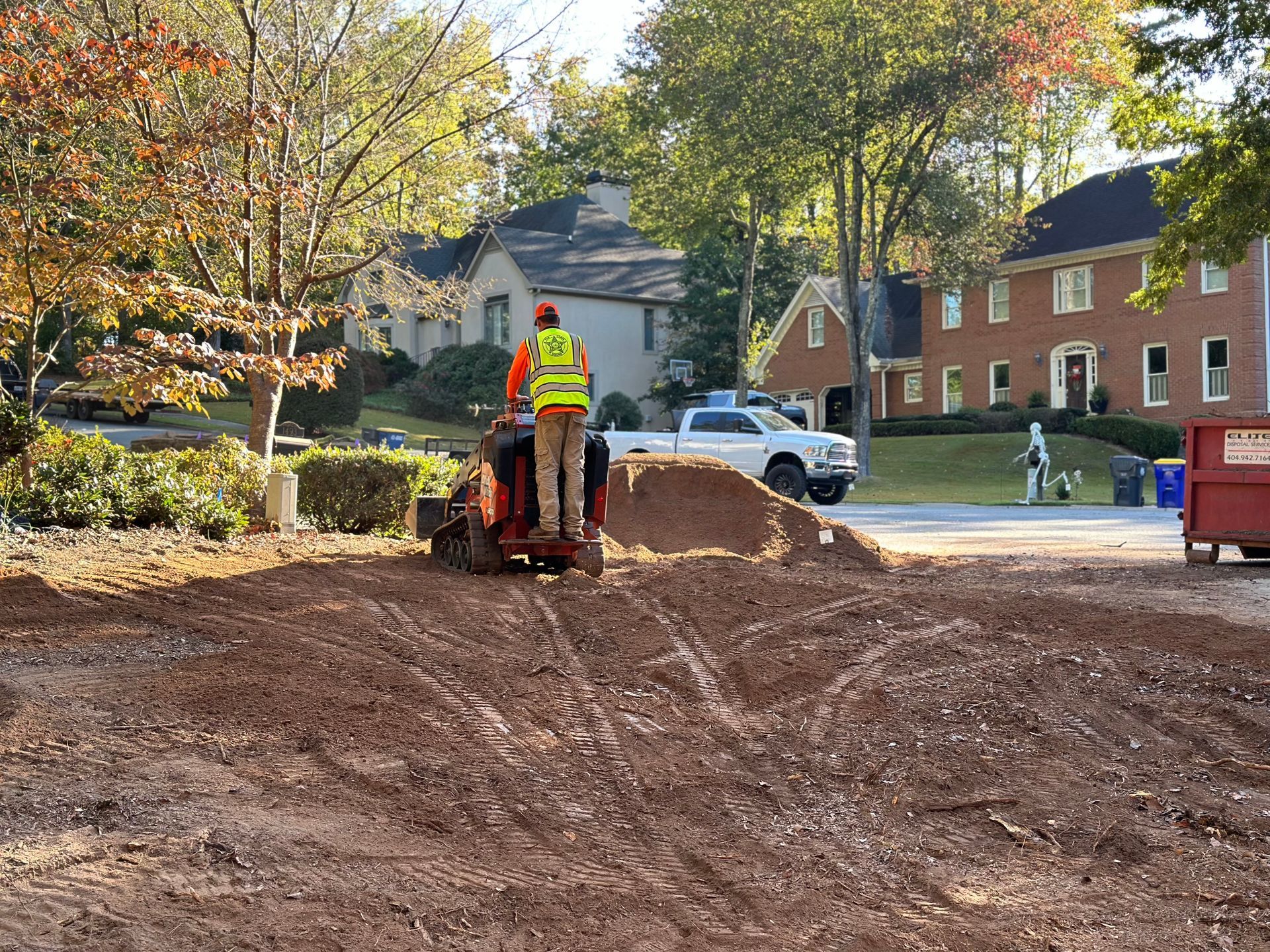 A man is riding a tractor in a dirt field.