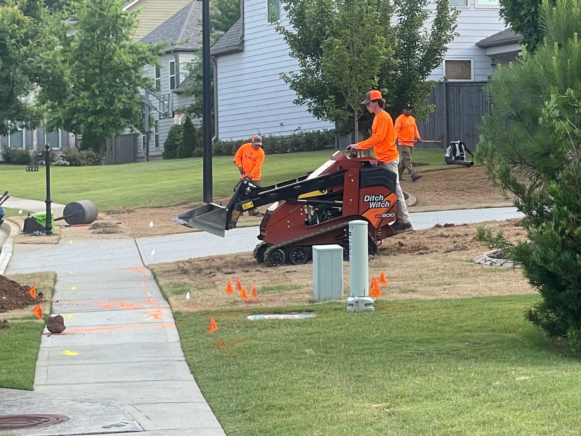 A group of construction workers are working on a sidewalk in a park.