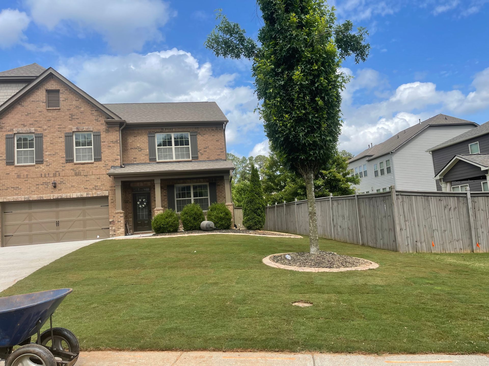 A large brick house with a large lawn in front of it.