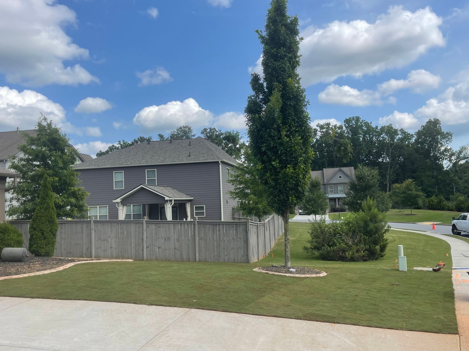 A fenced in yard with a house in the background