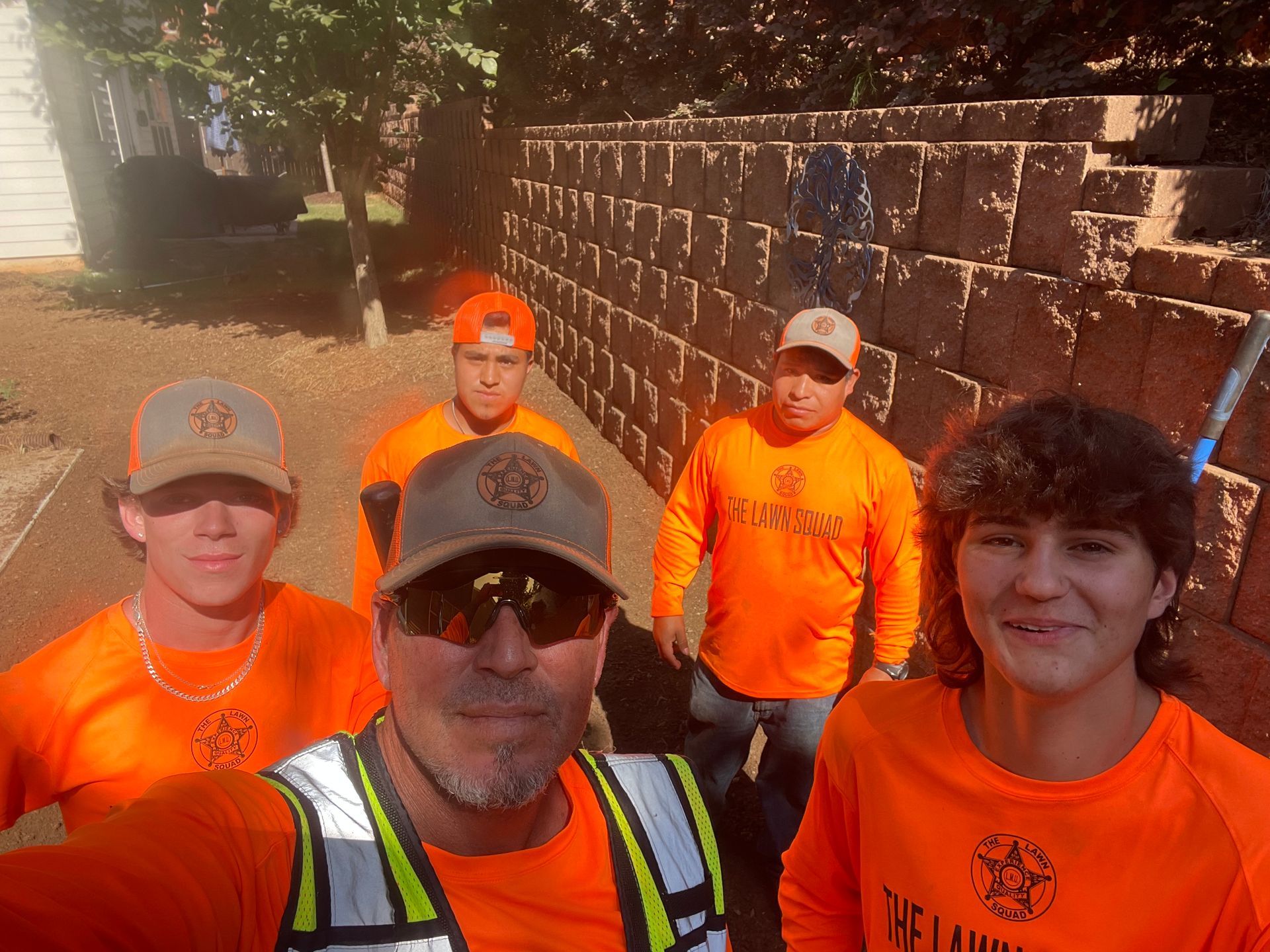 A group of people wearing orange shirts are posing for a picture.