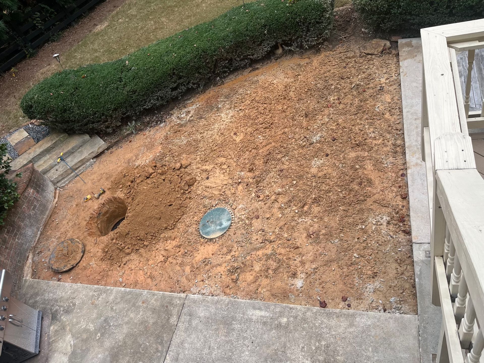 There is a hole in the ground in the middle of the yard.