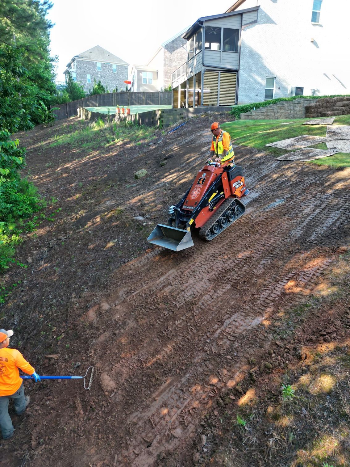 A man is riding a tractor on a dirt road.