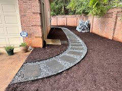 A walkway is being built in the backyard of a house.