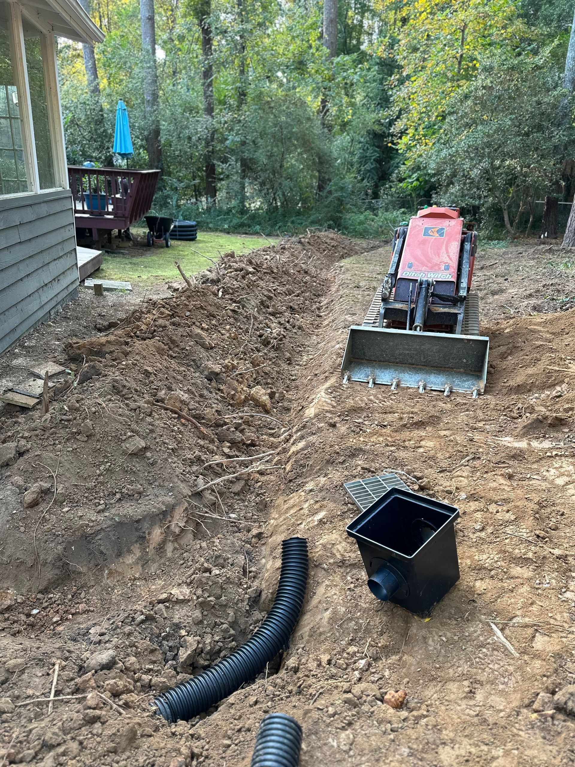 A bulldozer is sitting on top of a pile of dirt in a yard.