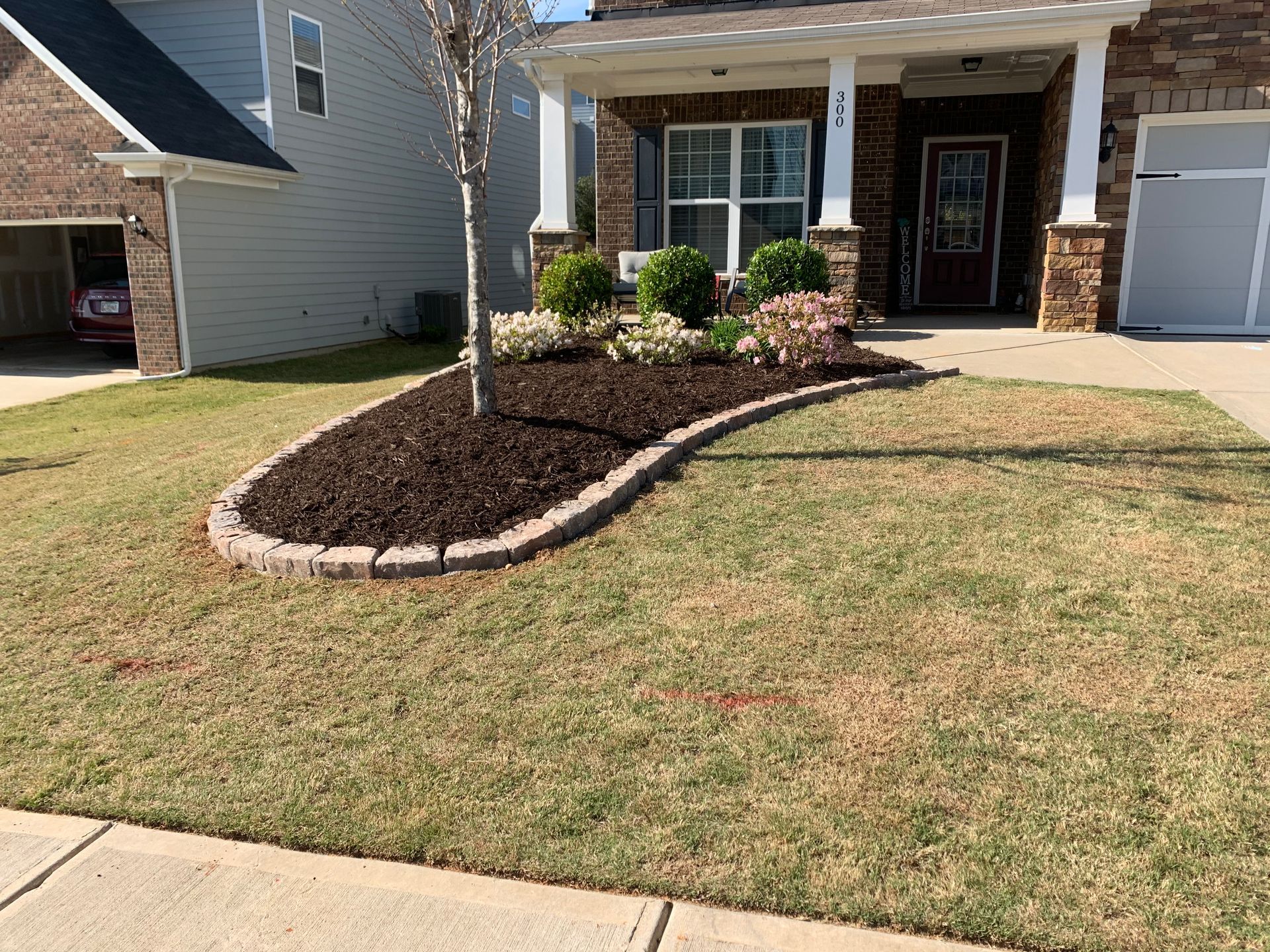 A house with a lush green lawn in front of it.