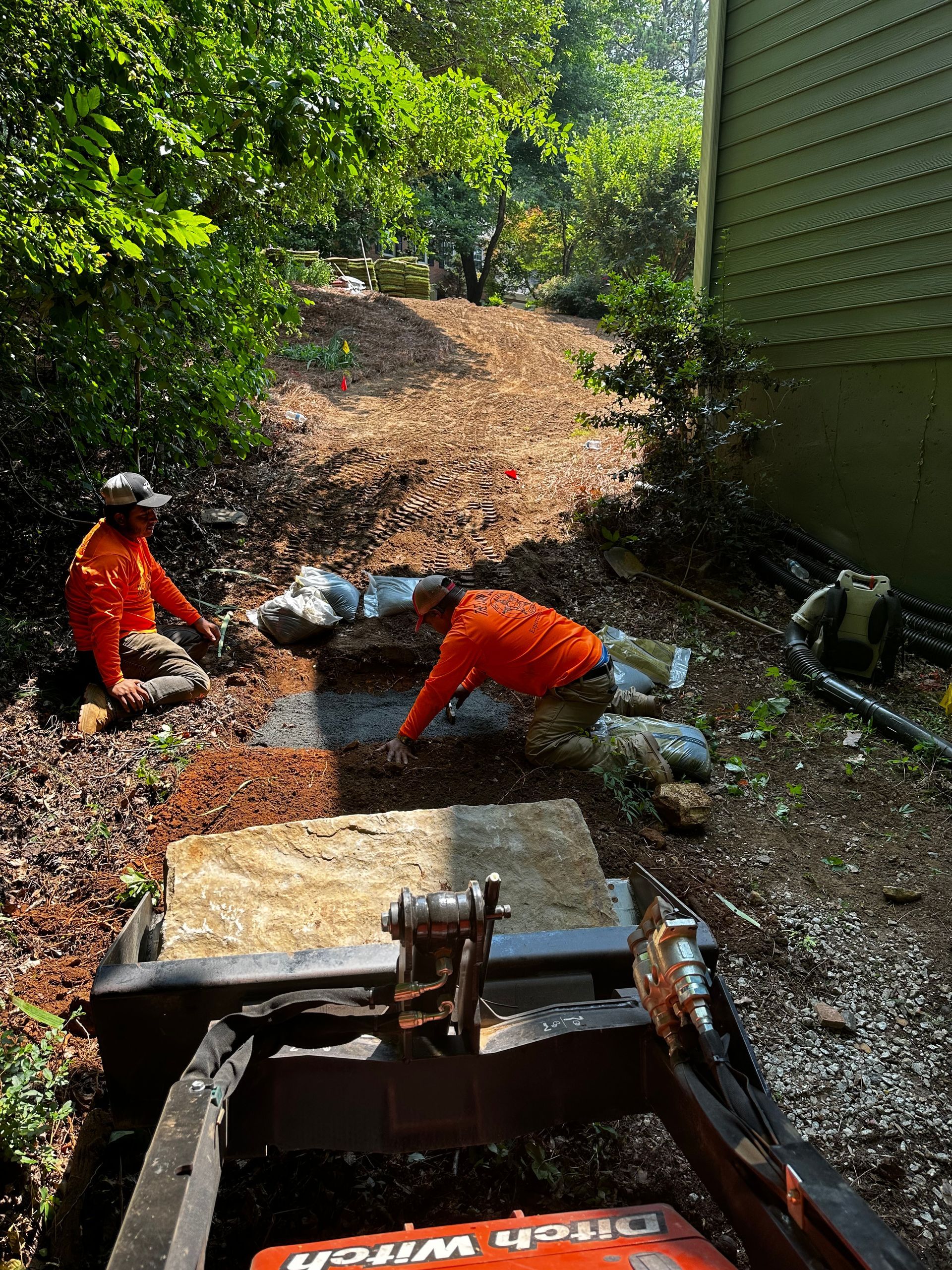 A man is working on a machine in a yard.