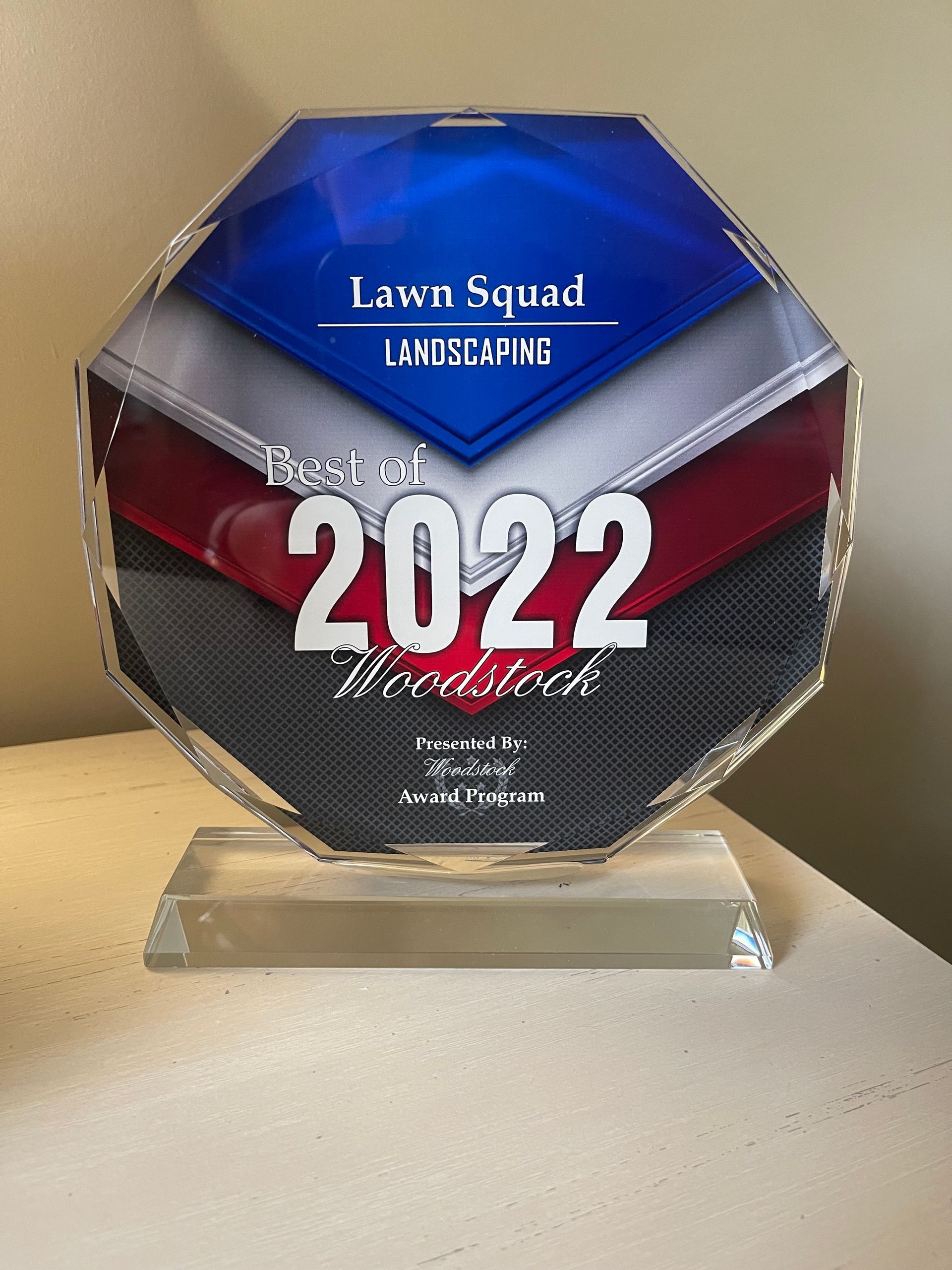 A plaque that says lawn squad landscaping 2022 is sitting on a table.