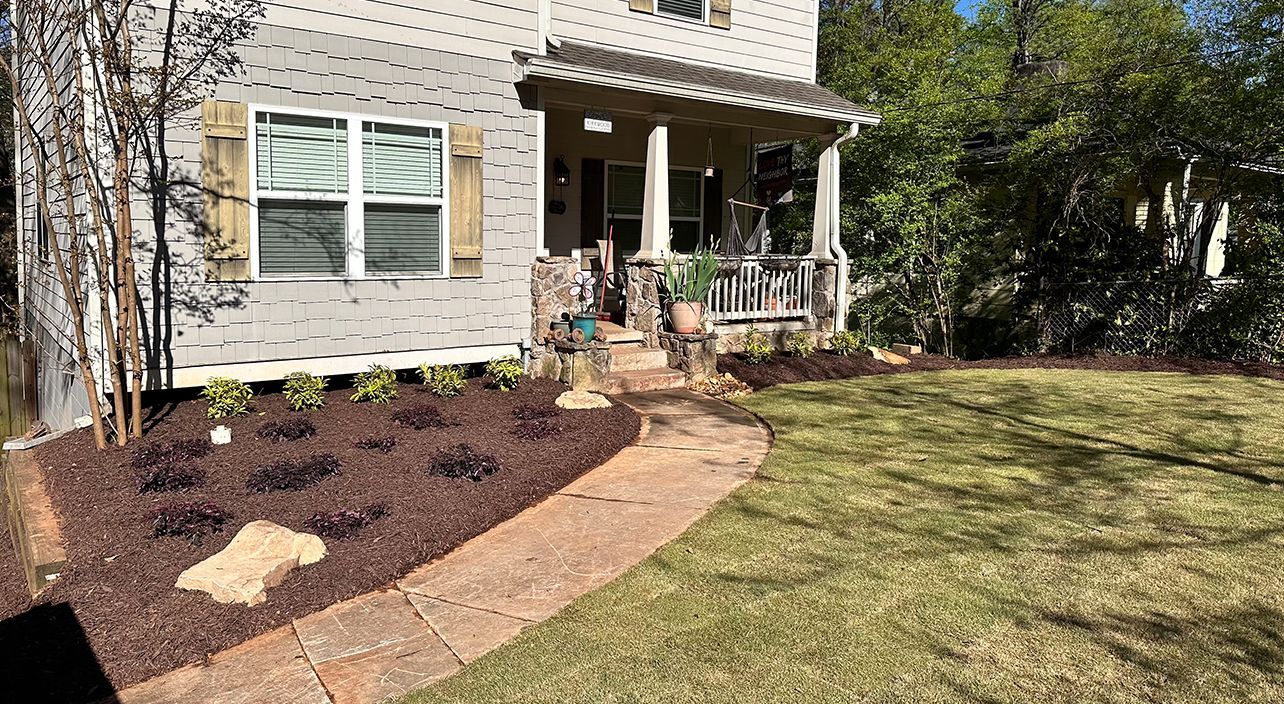 A house with a large lawn and a walkway in front of it.