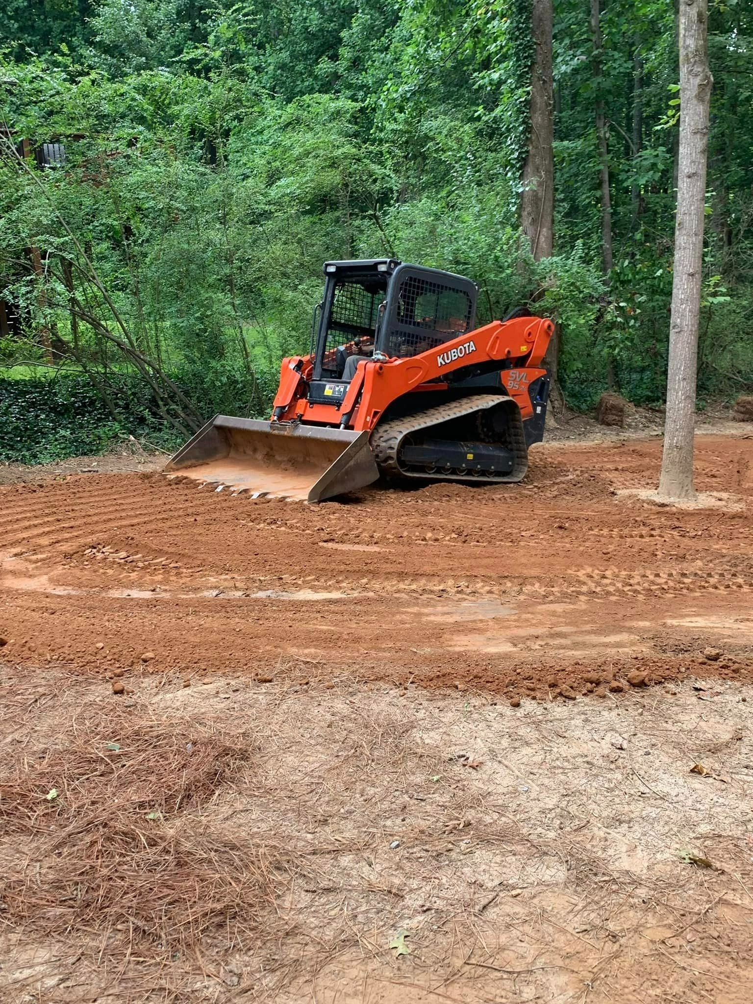 A bulldozer is sitting in the middle of a dirt field.