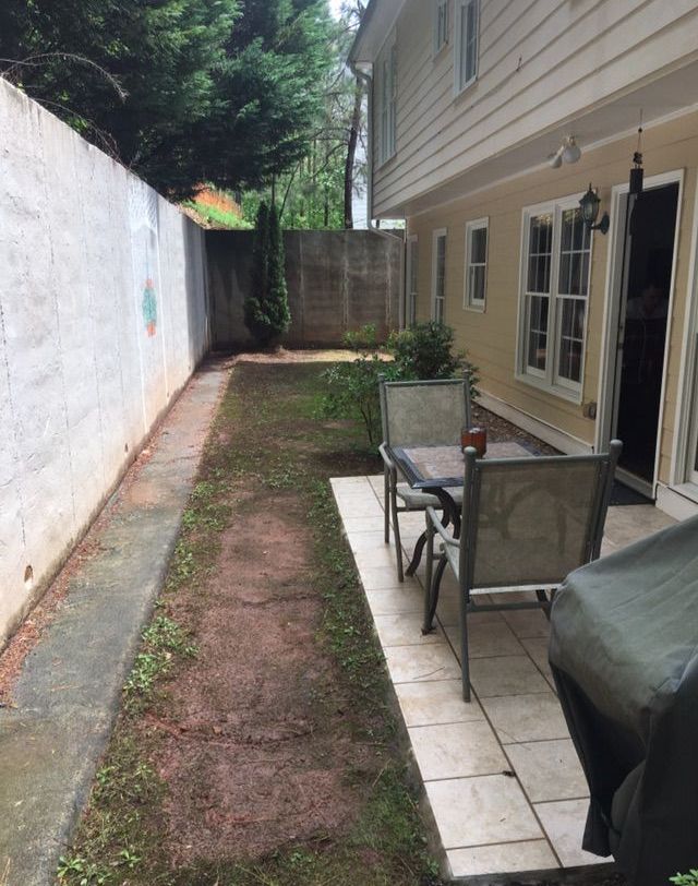 A phone screen shows a picture of a backyard with a patio.