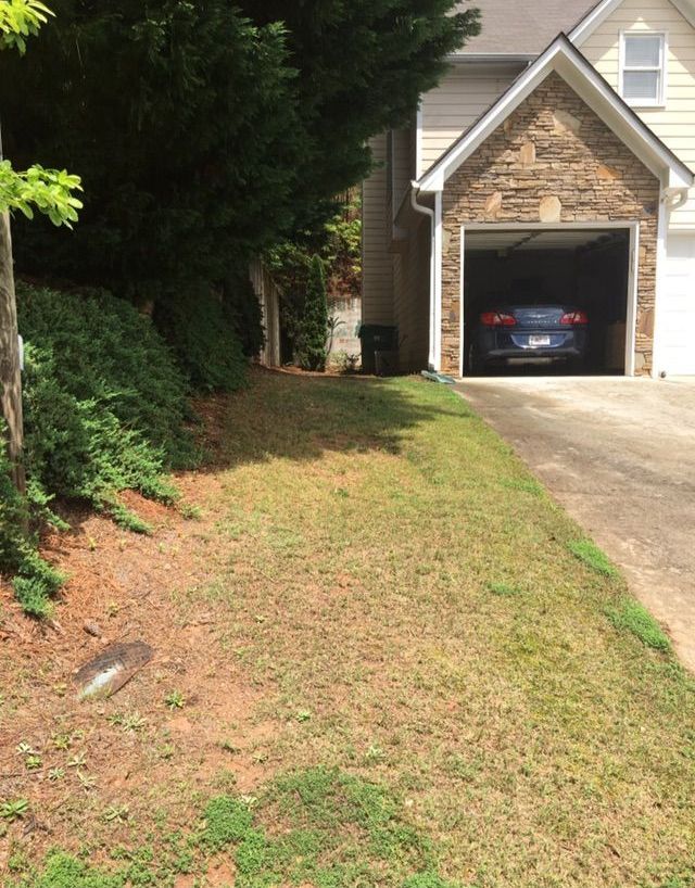 A picture of a house with a car in the garage