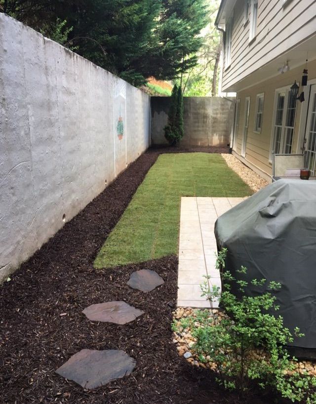 A phone screen shows a picture of a lawn in front of a house.