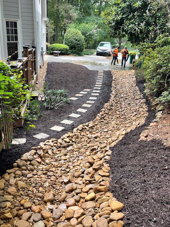 A walkway made of rocks and stepping stones leading to a house.
