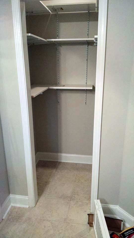 A closet with shelves and a door in a house.