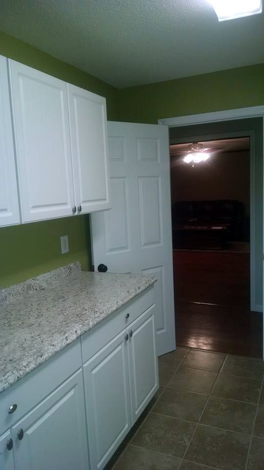 A kitchen with white cabinets and granite counter tops