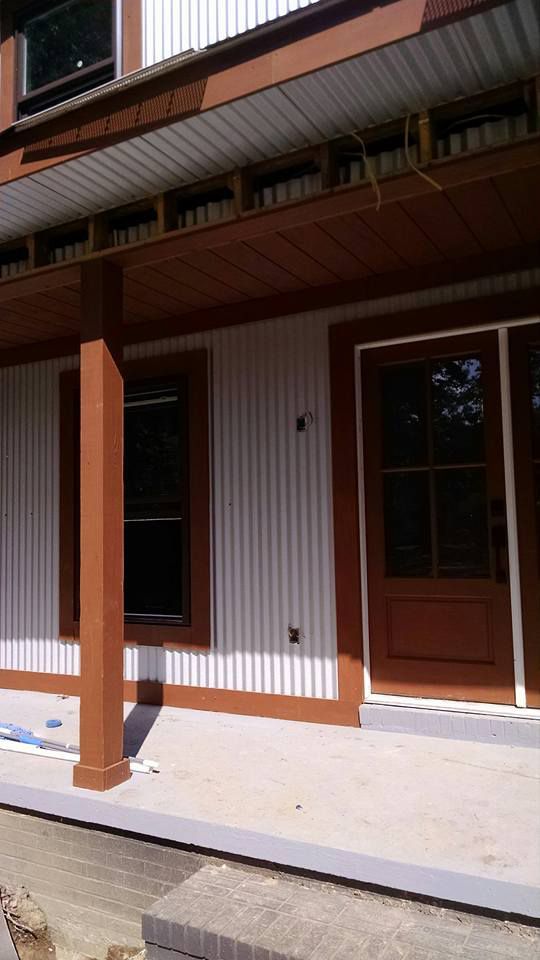 A house with a porch and a brown door