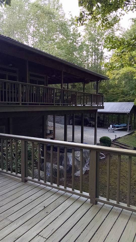 A large house with a large deck and a carport.