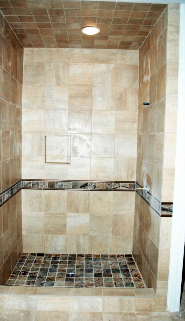 A bathroom with a walk in shower with a tiled floor.