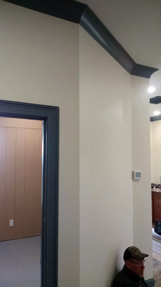 A man is sitting on a wall next to a door in a room.