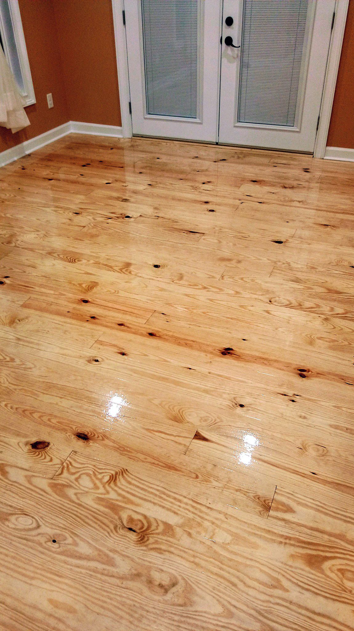 A room with a wooden floor and a sliding glass door.