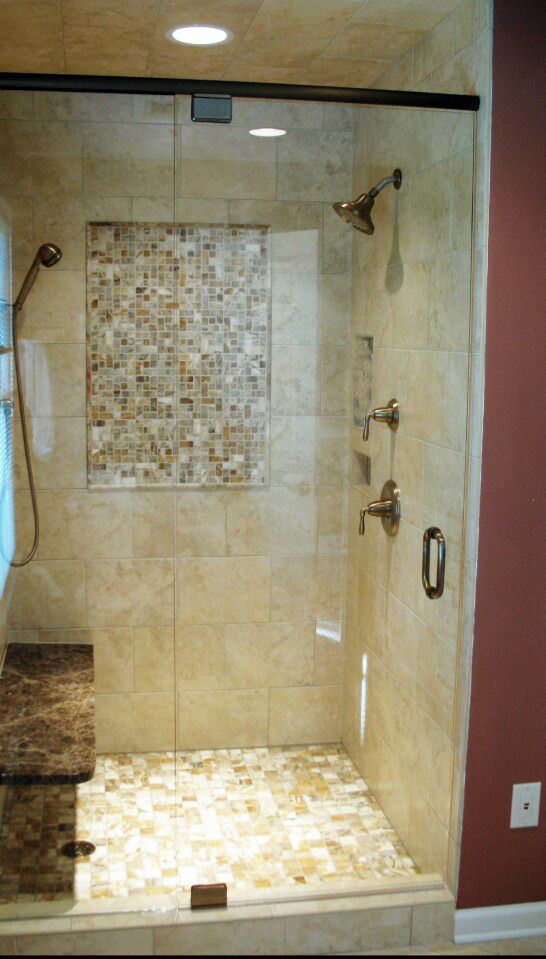 A bathroom with a walk in shower with a glass door.