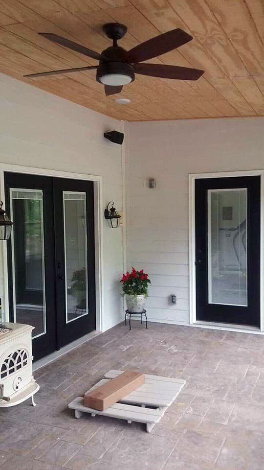 A ceiling fan is hanging from the ceiling of a porch.