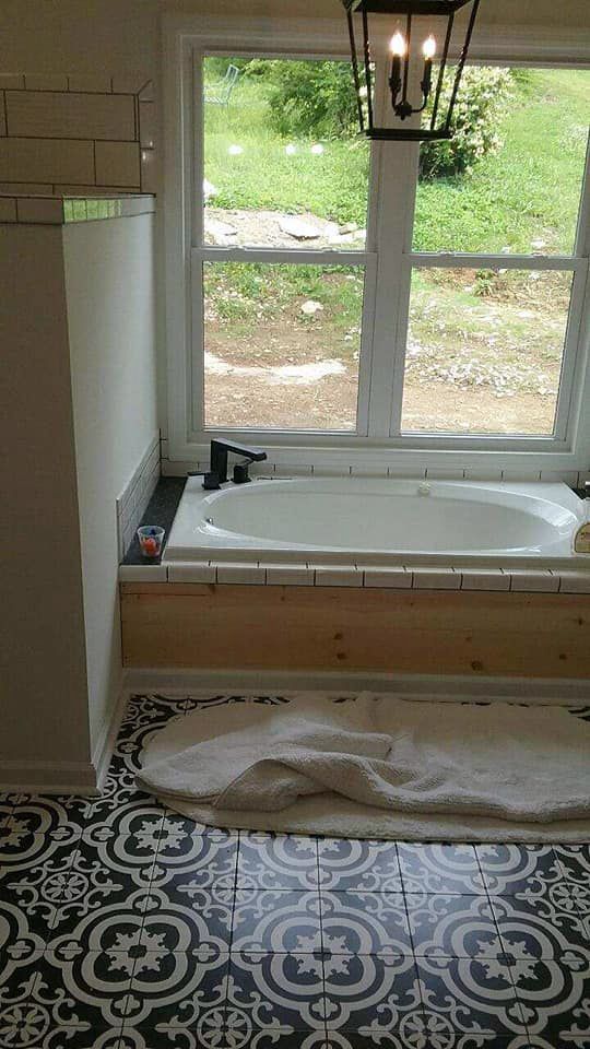 A bathroom with a bathtub and a window.