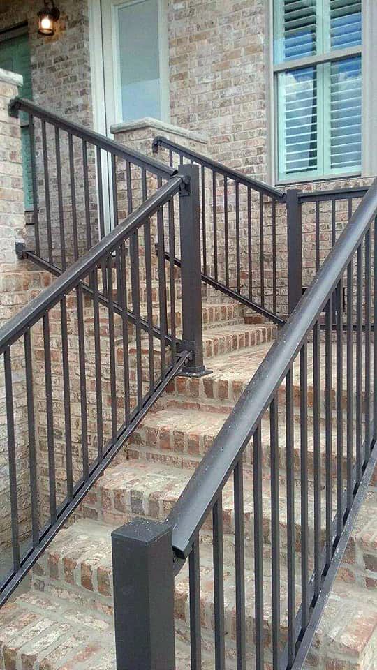 A staircase with a metal railing leading up to a brick building.