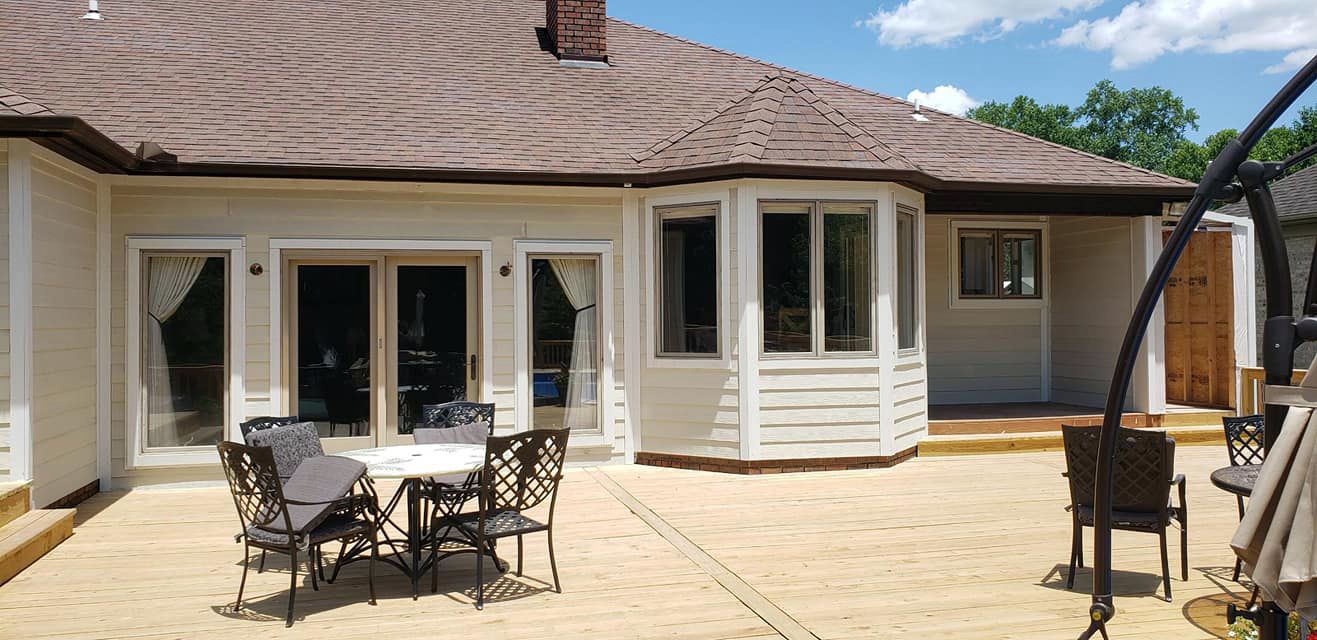 There is a table and chairs on the patio in front of the house.