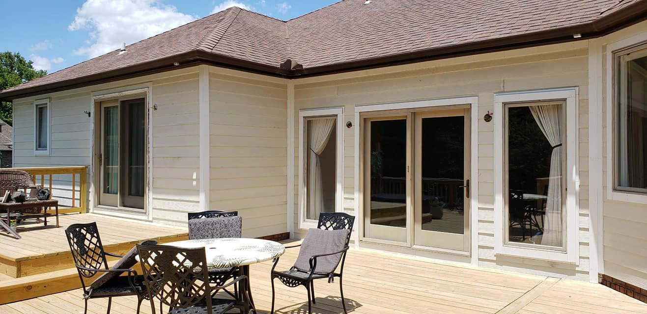 A patio with a table and chairs in front of a house.