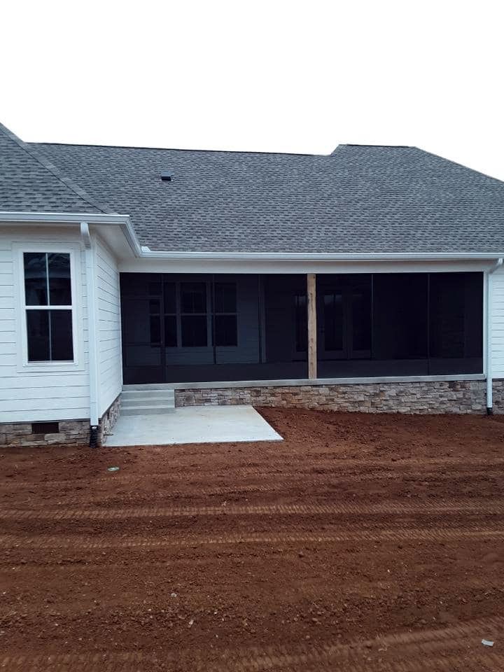 The back of a house with a screened in porch.